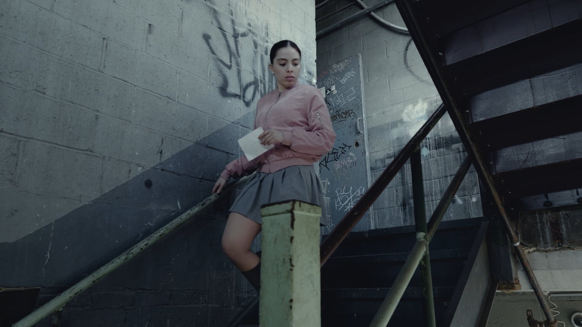 A Letter film still — reading a letter on a staircase