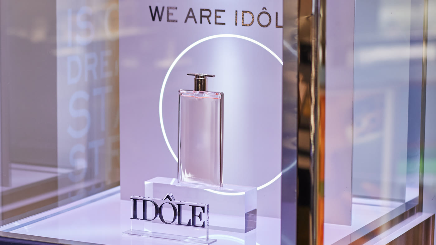 Idôle fragrance bottle in a lit window display
